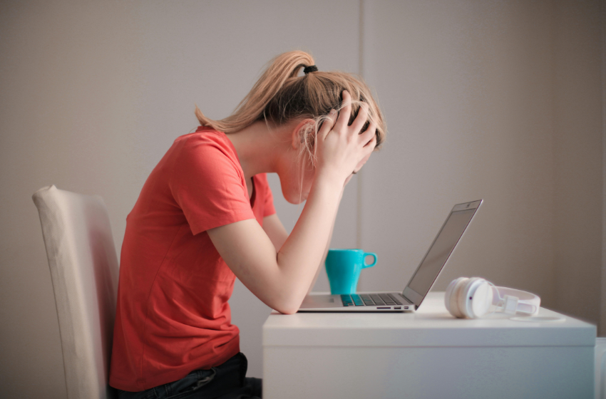 Persona estresada en entorno laboral reflexionando sobre incertidumbre y salud mental